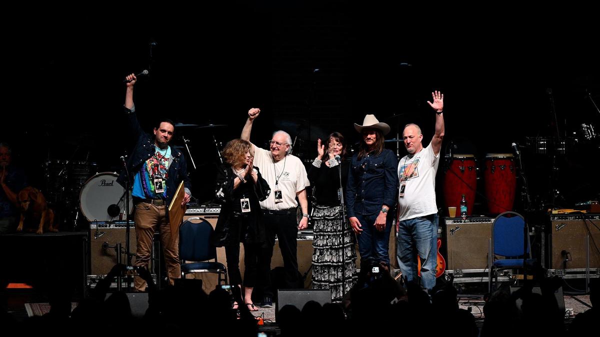 Macon-Bibb County mayor pro temper Seth Clark (left) and Macon-Bibb County mayor Lester Miller (far right) raise their hands in celebration with members of Dickey Betts’ family after declaring Feb. 28 “Dickey Betts Day” in Macon-Bibb County during the “In Memory of Dickey Betts” concert on Friday, Feb. 28, 2025, at the Macon City Auditorium in Macon, Georgia. Musicians from across the country gathered in Macon for a one night only, sold out concert honoring one of the original members of The Allman Brothers, guitarist Dickey Betts, who died in April 2024. All proceeds from the show went towards a scholarship in his name at the Berkelee College of Music in Boston.