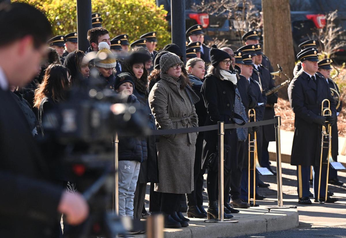 Carter Presidential Center staff and volunteers stand in the Circle of Flags after the hearse carrying former president Jimmy Carter left the center on Tuesday, Jan. 7, 2024, in Atlanta, Georgia. The Carter hearse and motorcade left the Carter Presidential Center and drove to Dobbins Air Reserve to fly to Washington D.C., where the former president will lie in state at the U.S. Capitol until Thursday.