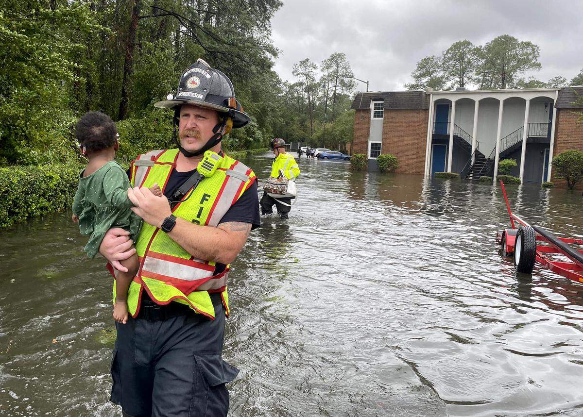 Valdosta firefighters help residents evacuate the Courtyards on Park apartment complex after Hurricane Idalia’s high winds and heavy rain swept through south Georgia.
