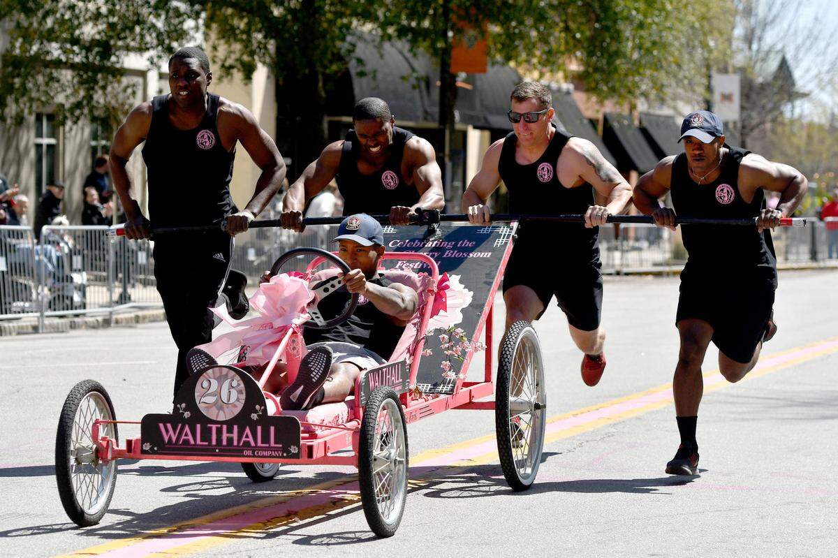 Members of the Macon-Bibb Fire Department race a bed down Cherry Street Saturday during the Cherry Blossom Festival Bed Race. The fire department won the event narrowly defeating a team of fire department recruits.