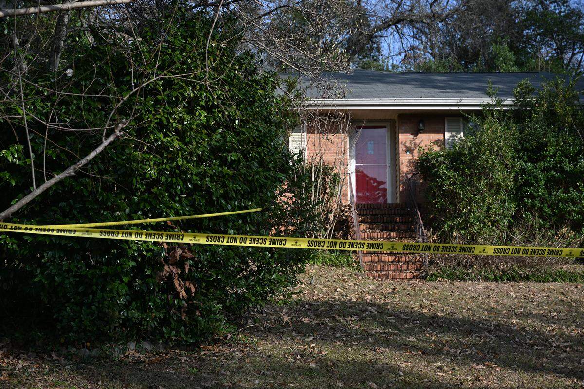 Crime scene tape surrounds the front yard of a house on Kay Drive on Tuesday, Jan. 7, 2026, in Warner Robins, Georgia. Police found a woman dead and a man unresponsive Wednesday morning in the home.