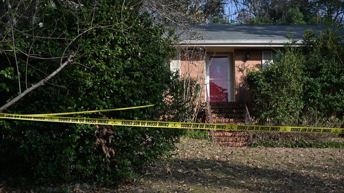 Crime scene tape surrounds the front yard of a Kay Drive house on Tuesday, Jan. 7, 2026, in Warner Robins, Georgia. Police found a woman dead and a man unresponsive in the house on Wednesday morning.