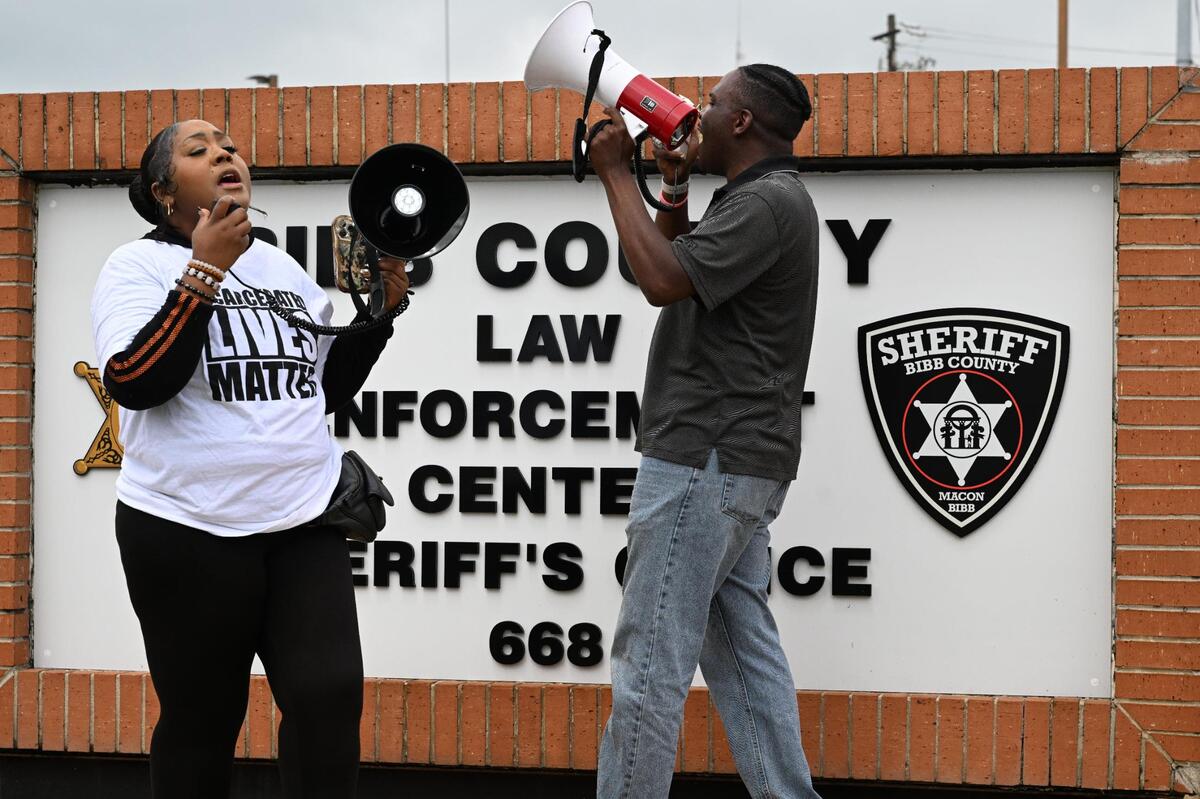 Protest organizers Shenita Bins (left) and Brian Randolph chant into megaphones in front of the Bibb County Sheriff’s Office on Wednesday, May 28, 2025, in Macon, Georgia. Dozens of local protesters as well as some from across the state gathered in Macon to protest conditions inside of the Bibb County Jail and called for more aggressive action from local officials.