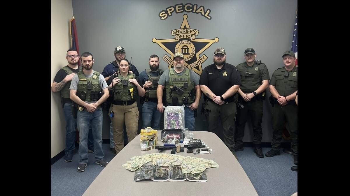 Deputies of the Ben Hill County Sheriff’s Office stand around evidence including around 581 grams, or 1.28 lbs, of marijuana, three handguns and more than $4,800 cash. Deputies said these items were seized during a drug operation in Fitzgerald, Ga., that allegedly involved three people including Kerrion Smith, a teacher and coach at Veterans High School, according to a Facebook post by the sheriff’s office on Sunday, March 1, 2026.