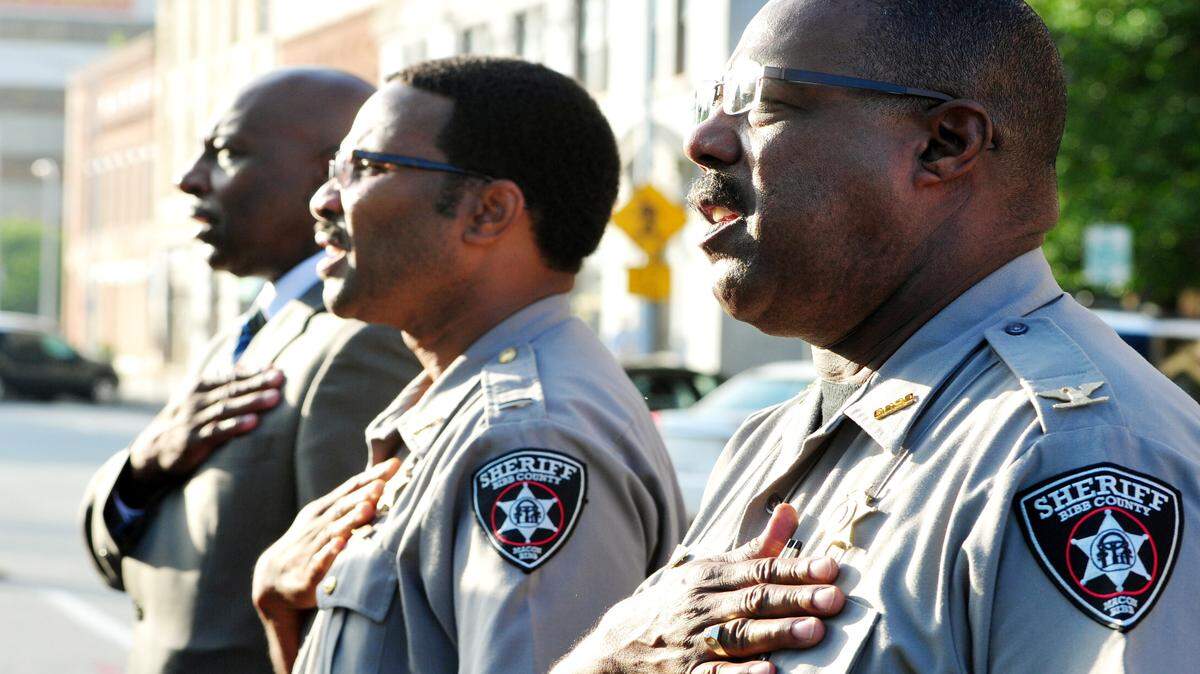 Bibb County Sheriff's Deputies Maj. Brady Fields, Elllis Sinclair and Col. Mike Carswell say the Pledge of Allegiance during the Macon-Bibb County Sept. 11 ceremony at Public Safety Memorial Park on Mulberry Street in 2014.
