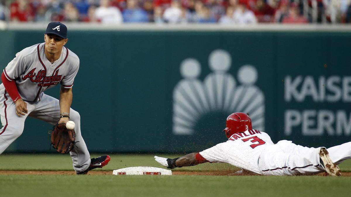 Atlanta Braves second baseman Jace Peterson, left, fails to handle the throw as Washington Nationals center fielder Michael Taylor (3) steals second base during the first inning of Monday's game.