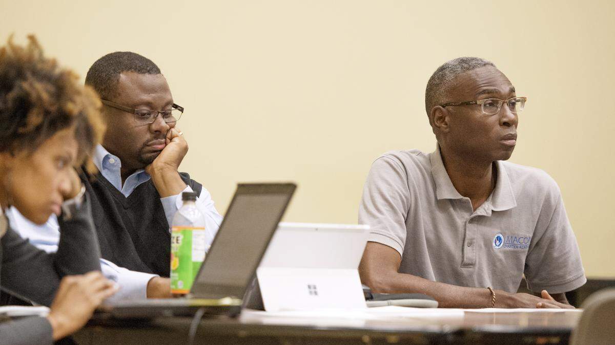 Macon Charter Academy founder Charles Rutland, right, listens during a board meeting at the school.