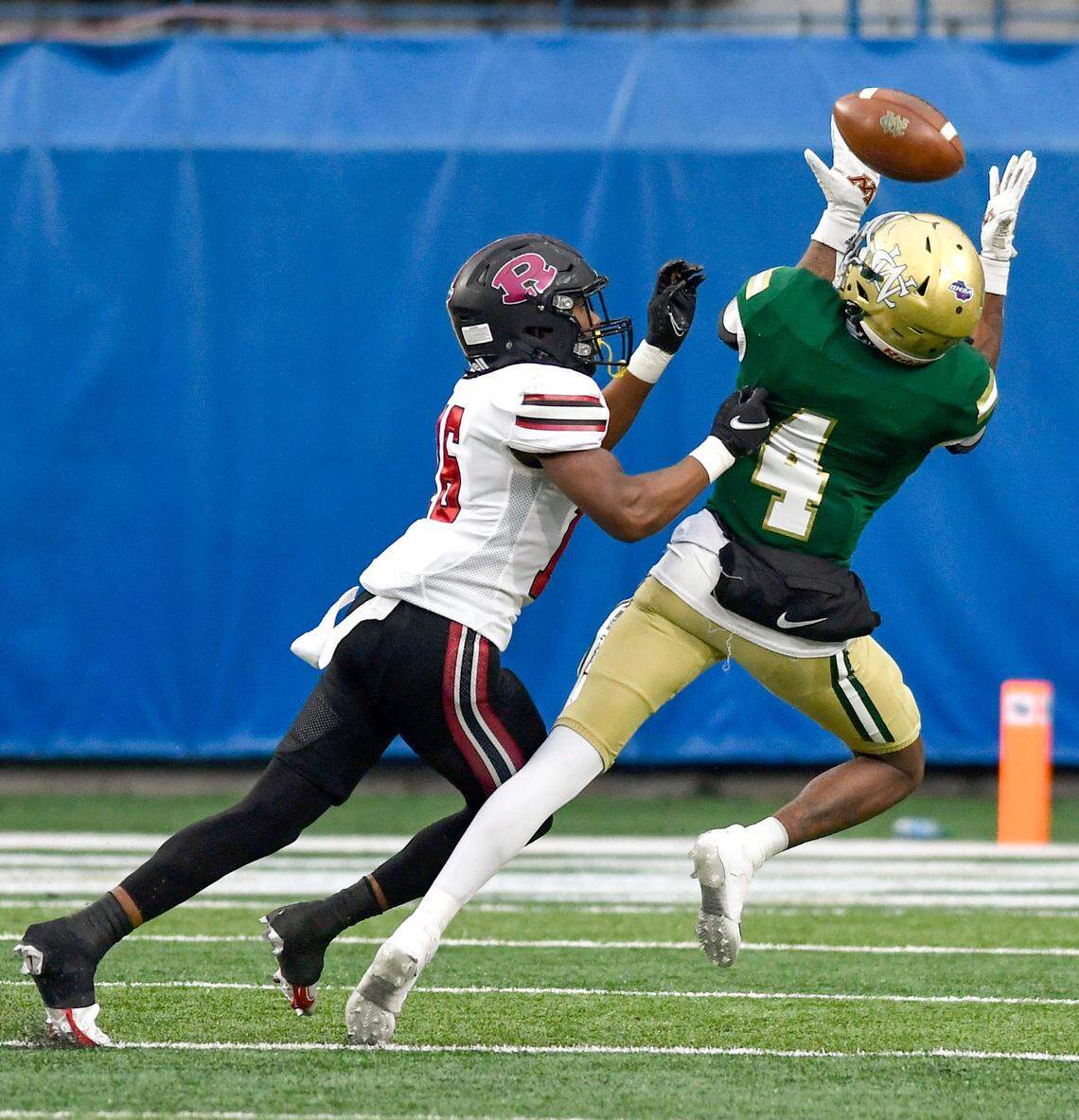 Ware County receiver Jarvis Hayes (4) hauls in a deep pass over a Warner Robins defender during their GHSA 5A championship game against Ware County Saturday in Atlanta.