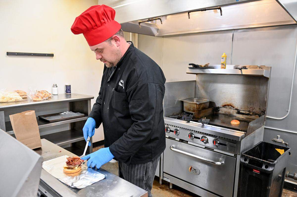 Jonathan Keene, owner and chef at Keen’s Kafe puts together a Keene’s famous steak burger. The burger, which sells for $12, features two Angus steak patties, muenster cheese, bacon, lettuce, red onion and pickles on a brioche bun along with a side of fries.