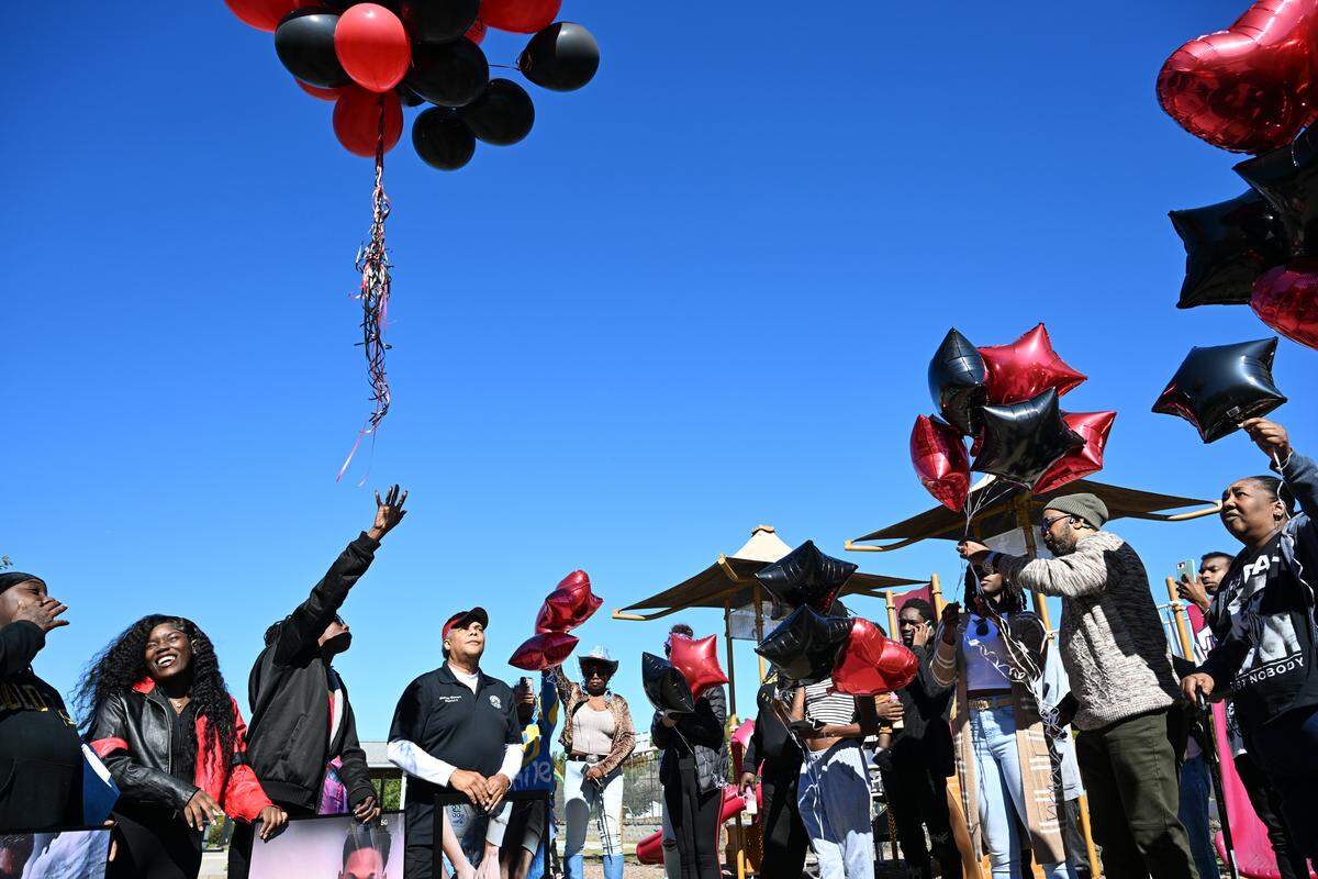 Friends, family and community leaders release red and black balloons to honor Contrel Dixon on Friday, Oct. 31, 2025, outside of Rosa Parks Community Center in Macon, Georgia. Twenty-four-year-old Contrel Dixon died in hospice in late October after he was shot at his home in Macon on July 4.