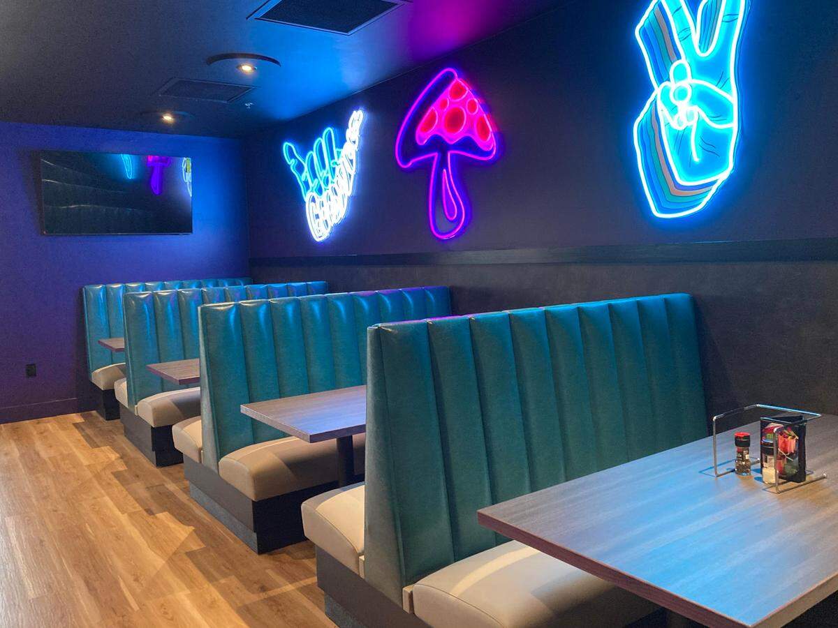 Newly added neon signs hang on a back wall at Mellow Mushroom in Warner Robins after a remodel.