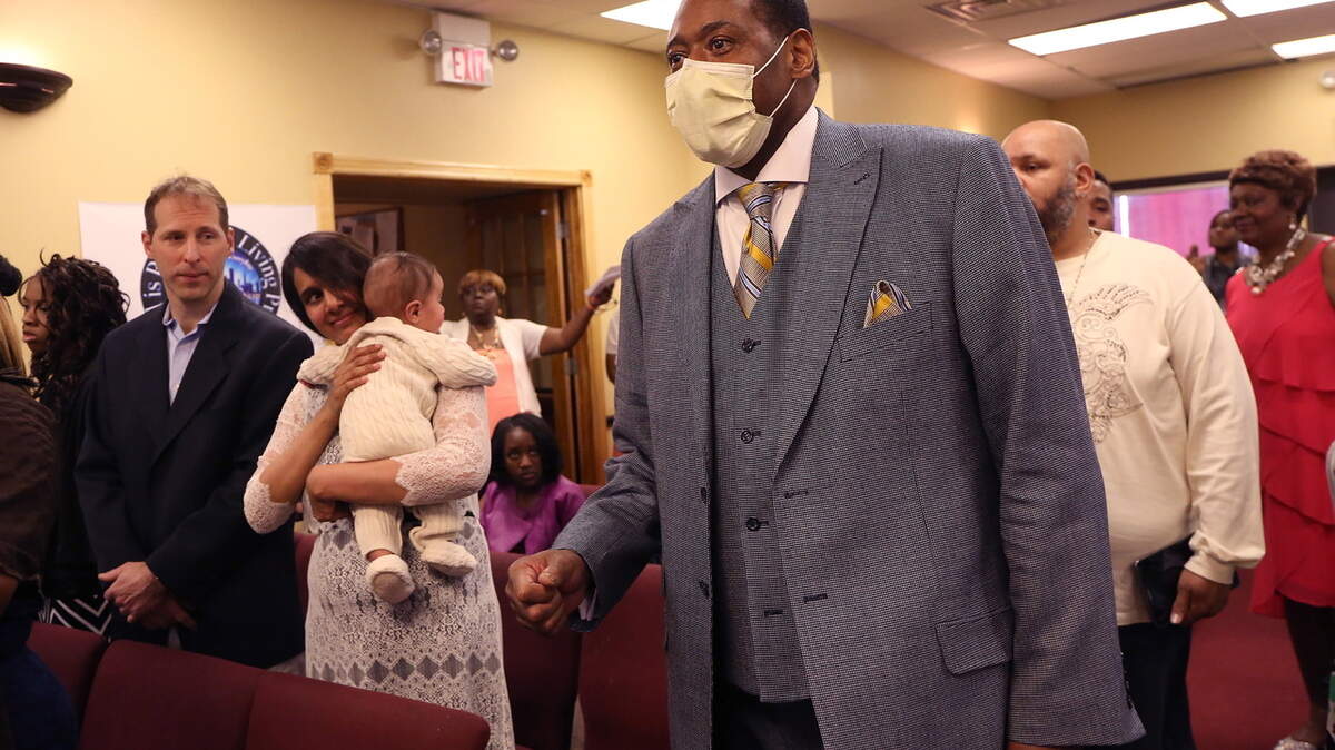 The Rev. Joseph Kyles enters his Chicago church to preach for the first time after his double lung transplant in March at The Promise Church of Chicago. At left are Dr. James Gagermeier, part of the lung transplant team at Loyola, and his wife, Hameeda Shaikh, a pulmonologist with the Edward Hines Jr. VA Hospital, and their son Leo.