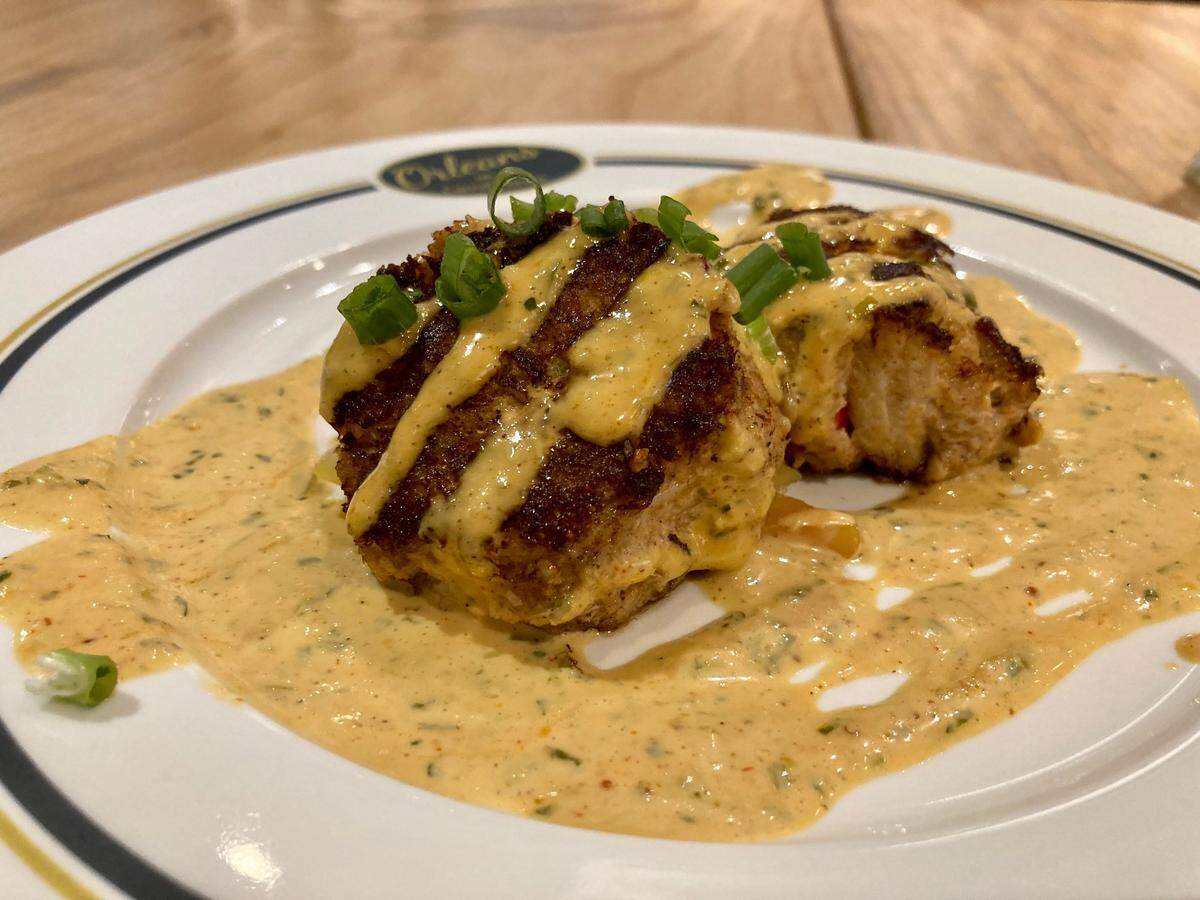 Two pan seared crab cakes served with homemade chow-chow and drizzled with remoulade at ‘Orleans on Carroll Street in downtown Perry.