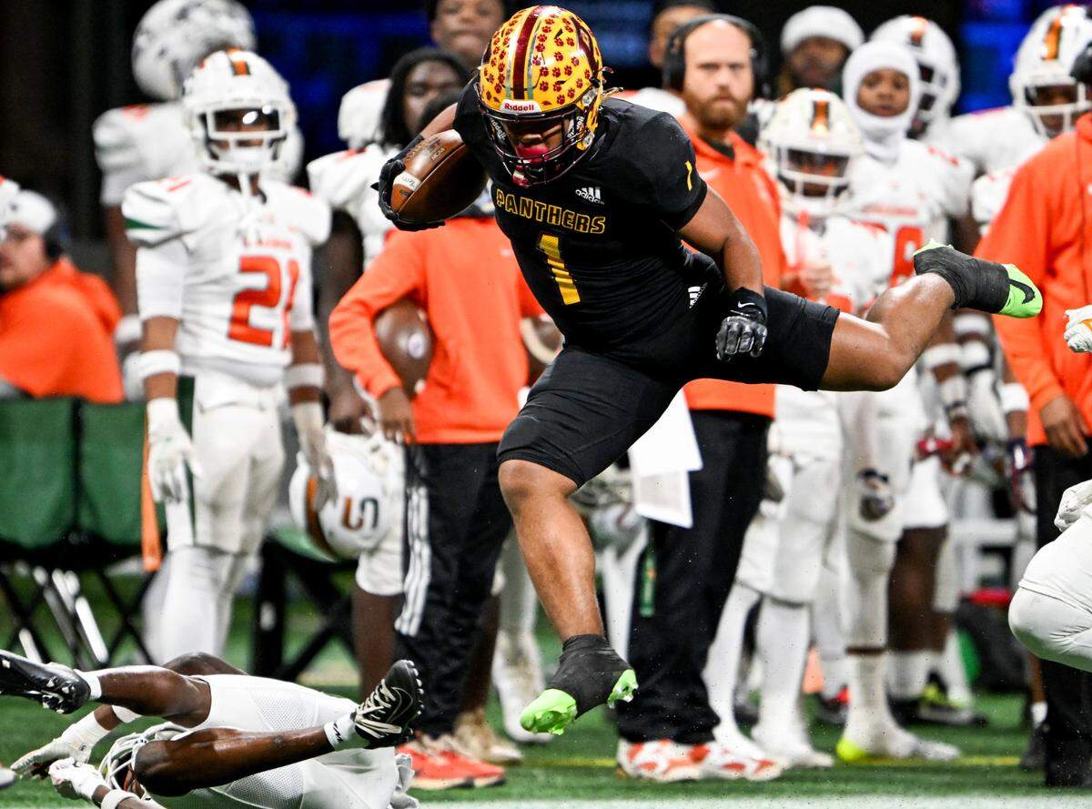 Perry running back Ahmad Gordon (1) leaps over a defender along the sideline during the Pamthers’ GHSA 4A State Championship win over Stockbridge Tuesday in Atlanta.