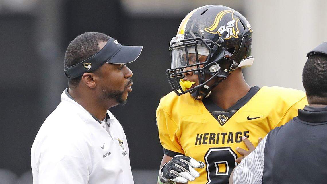 American Heritage Patriots head coach Patrick Surtain talks with Tyson Campbell (8) as American Heritage plays Baker County Wildcats in Class 5A State High School Football Championship at Camping World Stadium in Orlando on Dec. 8, 2017.