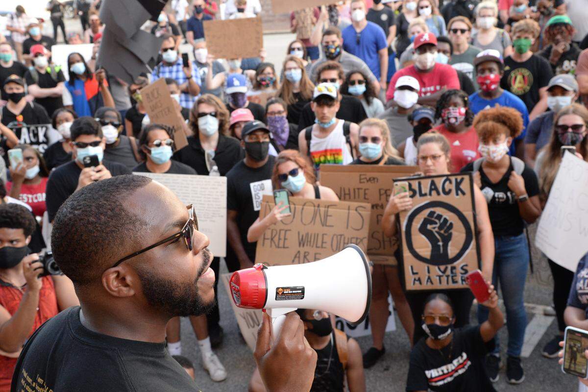 Juawn Jackson reads the names of black men and women killed by law enforcement officers in the United States over the past few years during a march through downtown Macon Tuesday evening. Marchers gathered in front of the Tubman Museum and stopped for speeches in front of city hall and the county courthouse.