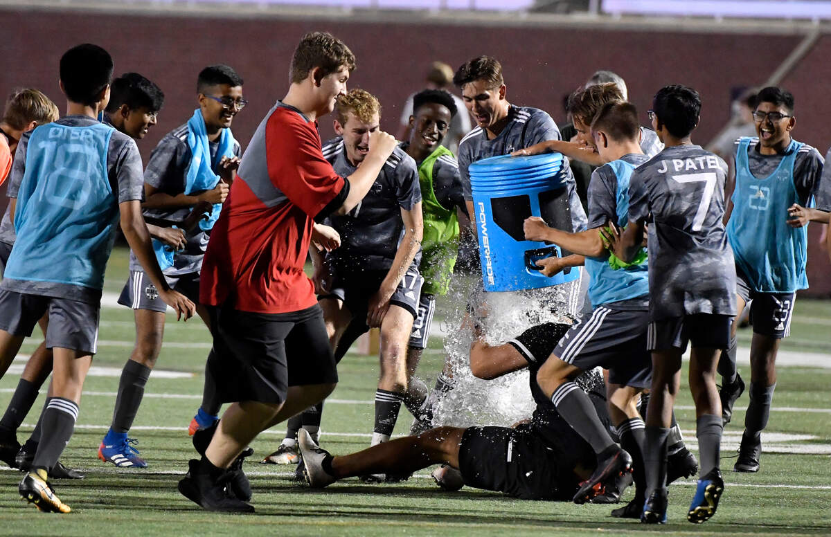 GMC players dump a bucket of water on coach Bobby Jaworski after the BulldogsÕ GHSA 1A State Championship win over ACE Friday night at Mercer.