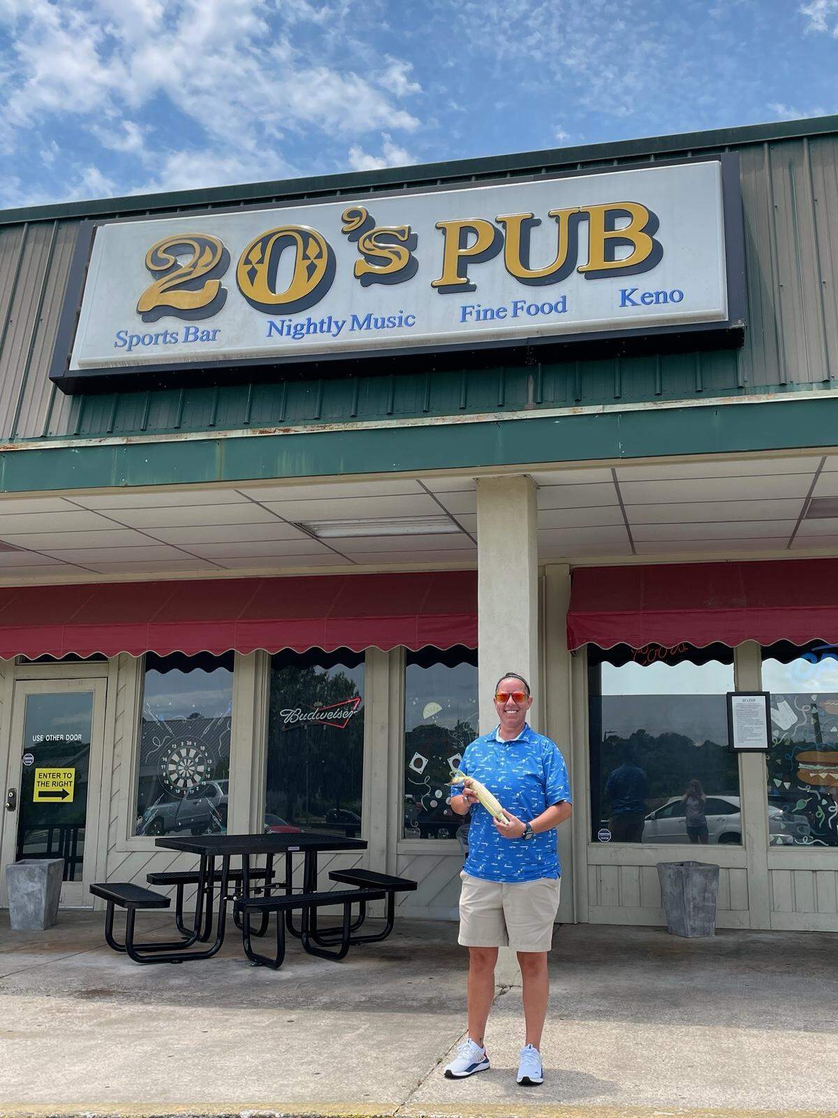 Director of Marketing and Entertainment Lisa Williams stands outside 20’s Pub with a fresh ear of corn from Everett Farms. The restaurant has partnered with the farm to offer farm-to-table dishes with fresh produce.