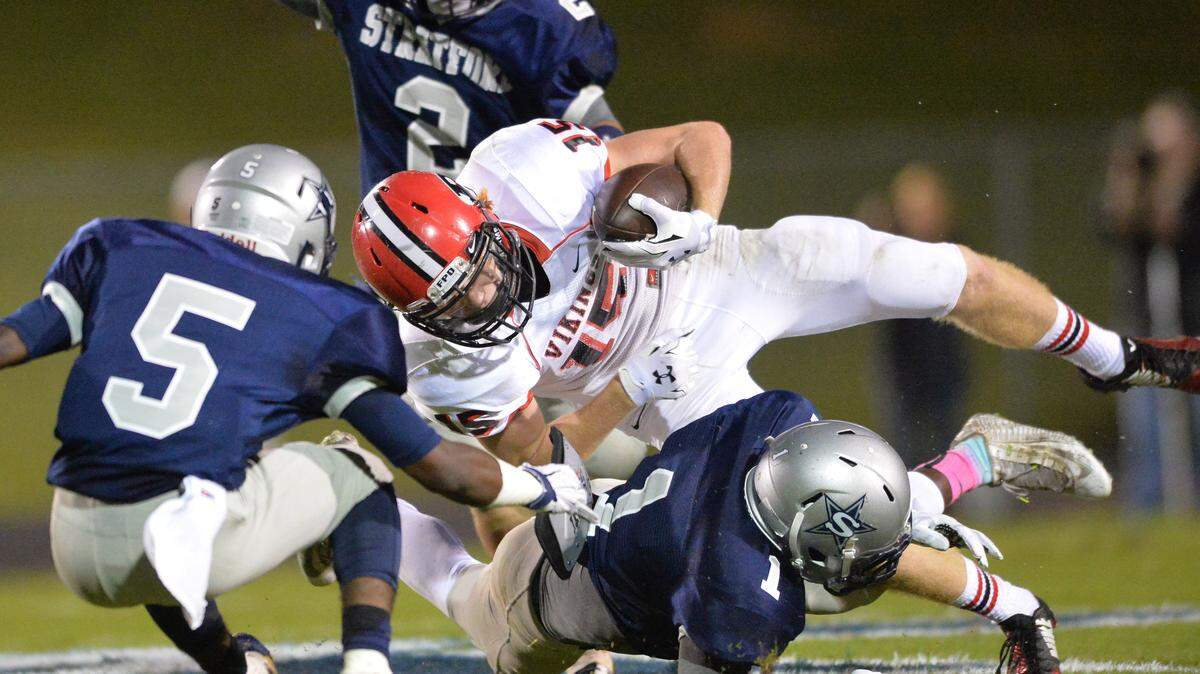 FPD's Daniel Weaver is tripped up at the line by Stratford's Quintez Cephus (1) and Noah Hill (5) during their game in early October.