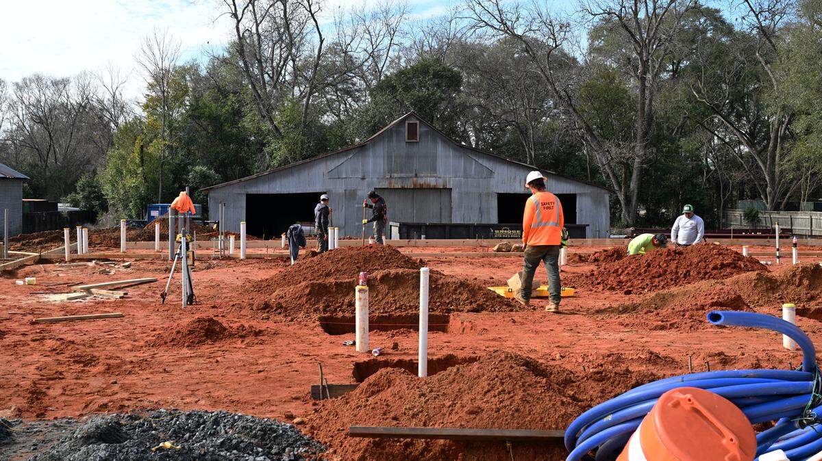 Construction crew members work on the property of the future home of Left at the Pig Brewery in historic downtown Perry.