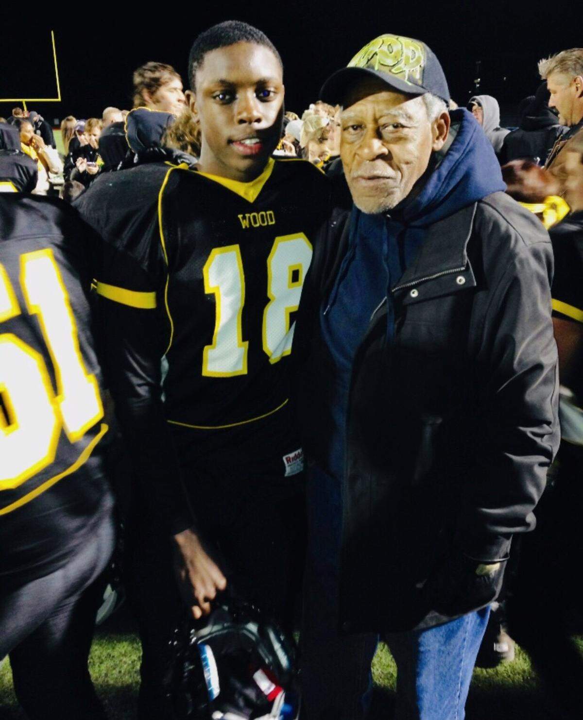 Mark Webb, Jr. (left) and his grandfather Roosevelt Webb stand for a photo after a high school football game.