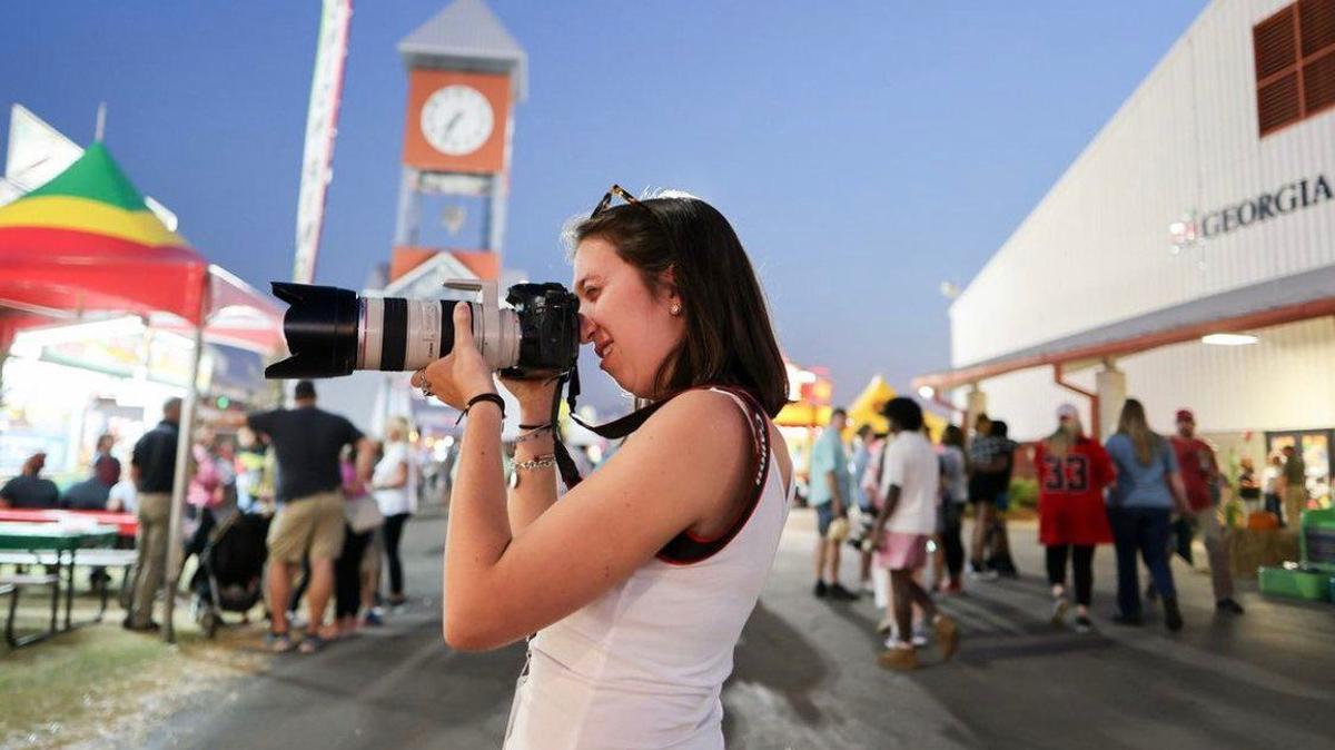 Katie Tucker photographs a booth at the Georgia National Fair as a part of the University of Georgia Advanced Photojournalism workshop on Friday, October 14, 2022, in Perry, Georgia. (Photo/Mark Johnson)