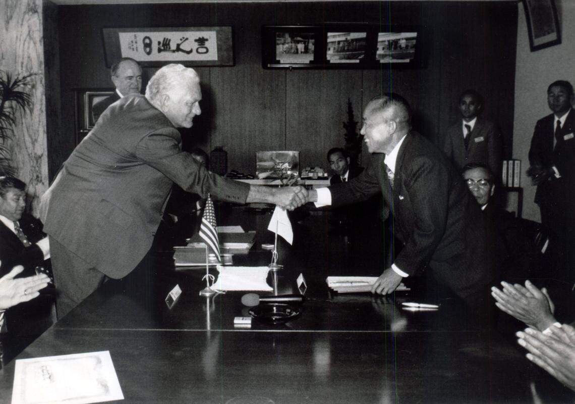 Officials sign the land contract in Kurobe, Japan to build Japanese-based YKK in Macon, Georgia.