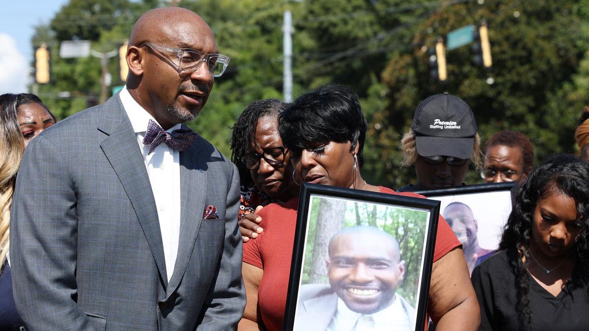 Attorney Mawuli Davis of Davis Bozeman Law stands with Paula Platt, mother of Stephen Fossett, who holds a picture of her son during a press conference discussing an investigation into Fossett’s death on Wednesday, Aug. 28, 2024, outside of the Bibb County Jail in Macon, Georgia. Fossett died in late May while in custody at the Bibb County Jail after experiencing a medical emergency and subsequent tasing.