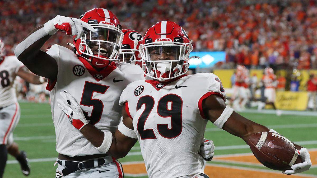 Georgia defensive back Christopher Smith celebrates with Kelee Ringo, left, after intercepting a Clemson pass and returning it for a touchdown during the second quarter of an NCAA college football game Saturday, Sept. 4, 2021, in Charlotte, N.C. (Curtis Compton/Atlanta Journal-Constitution via AP)