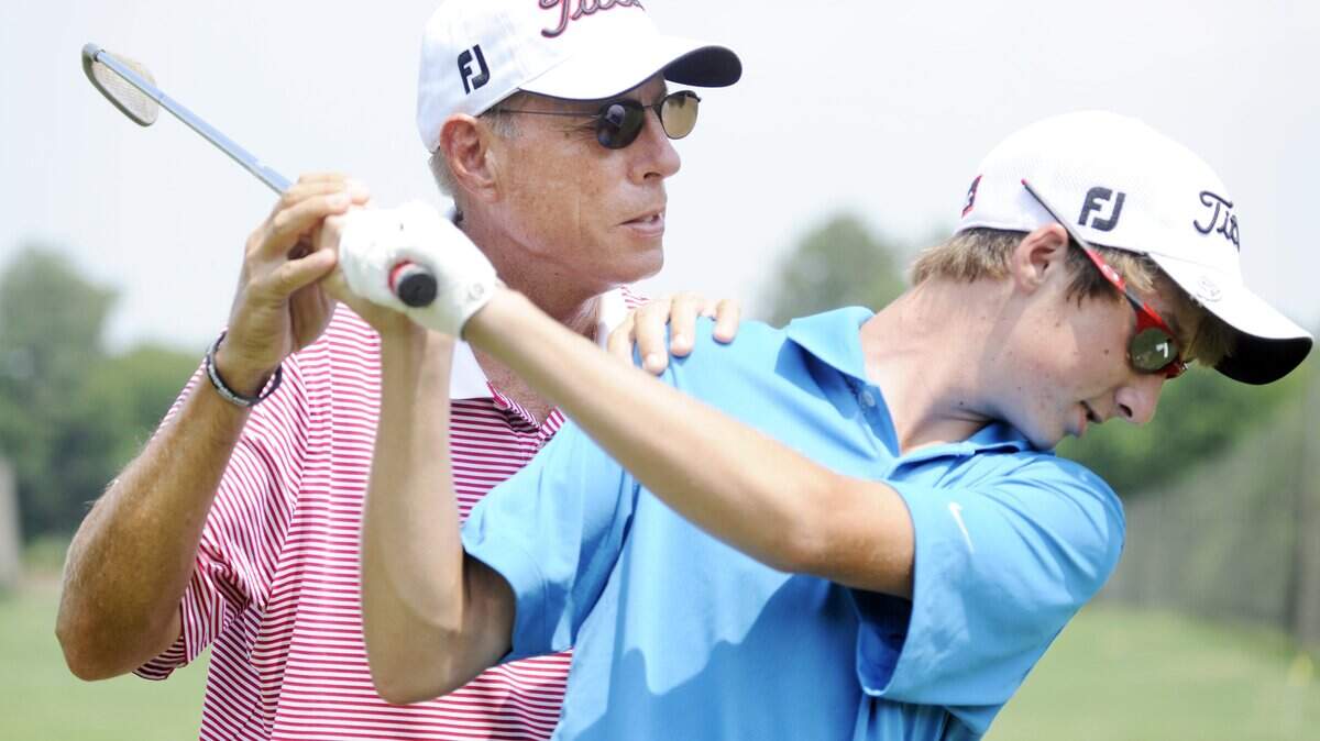 Bobby Hix helps Austin Penny of Griffin with his backswing during a golf lesson in 2011 at Idle Hour Country Club.