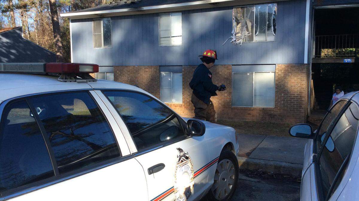 Lt. Ben Gleaton takes his camera to photograph fire damage Tuesday morning at Riverbend Apartments at 3645 Mercer University Drive. Grease on the stove is believed to have caused Monday night's blaze that burned through the roof of building 7.