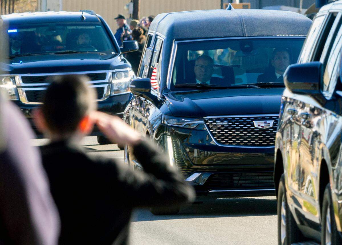 A young man salutes to a hearse carrying the remains of former President Jimmy Carter in Plains, Ga. on Saturday, Jan. 4, 2025.