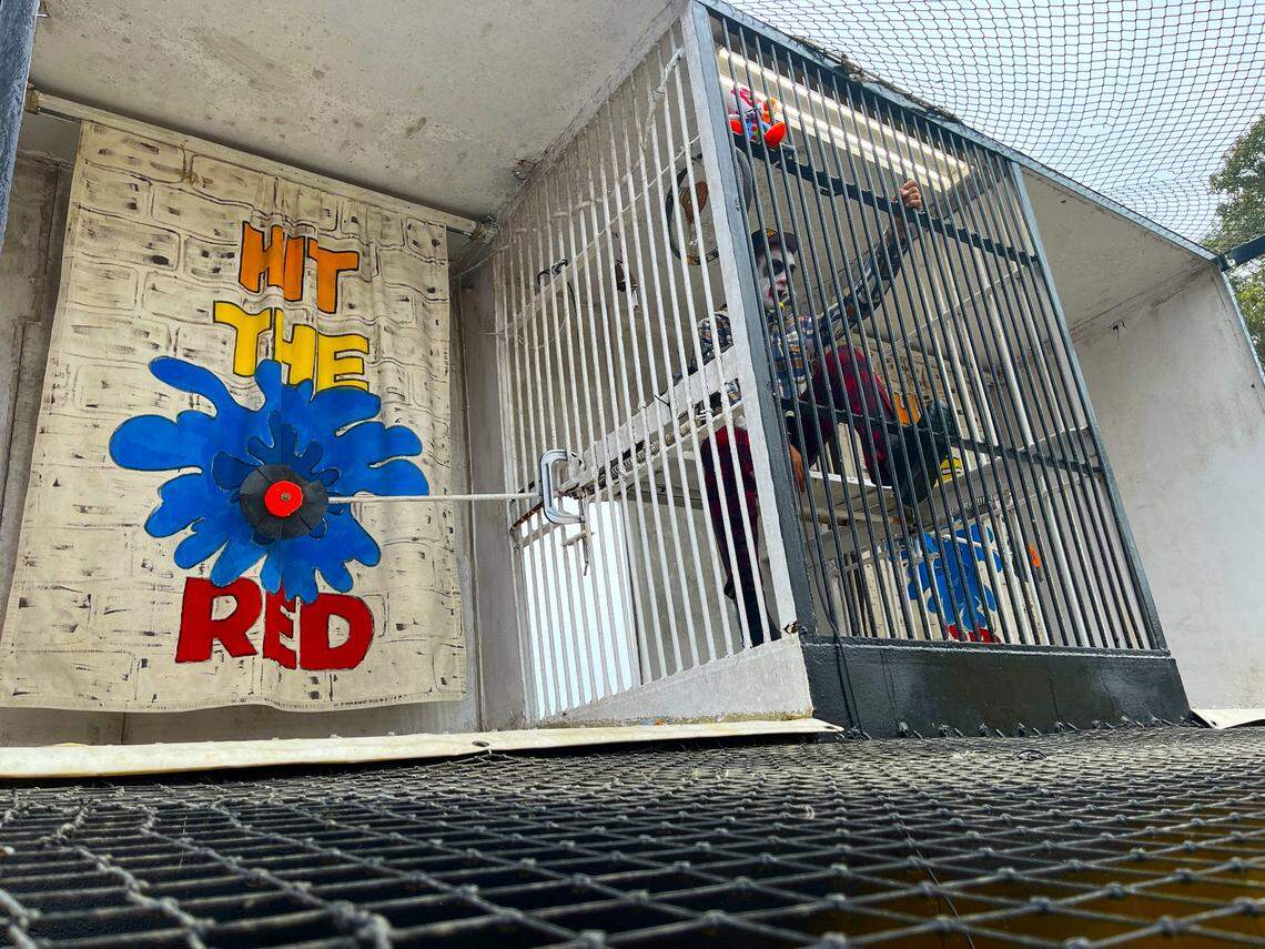 The object of the Soak The Bloke dunking booth game is to hit the target with a rubber baseball. When smacked, the target knocks loose a spring that drops a clown into a water tank below.