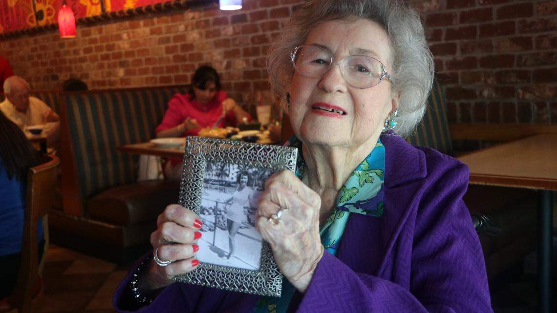 Virginia Pair Witherington holds a photo of herself in her younger days during her 105th birthday party on Sunday.