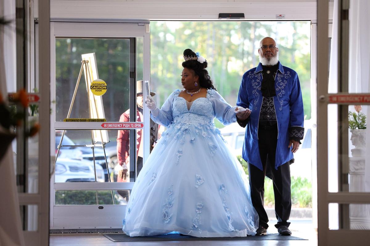 Event organizer Sabrina Smith (left) enters the venue with Lawrence Smith at Queen Elizabeth’s Royal Ball at the Anderson Conference Center on Saturday, April 26, 2025, in Macon, Georgia. Guests dressed in regency era ballgowns and suits at the event inspired by the hit Netflix series “Bridgerton.”