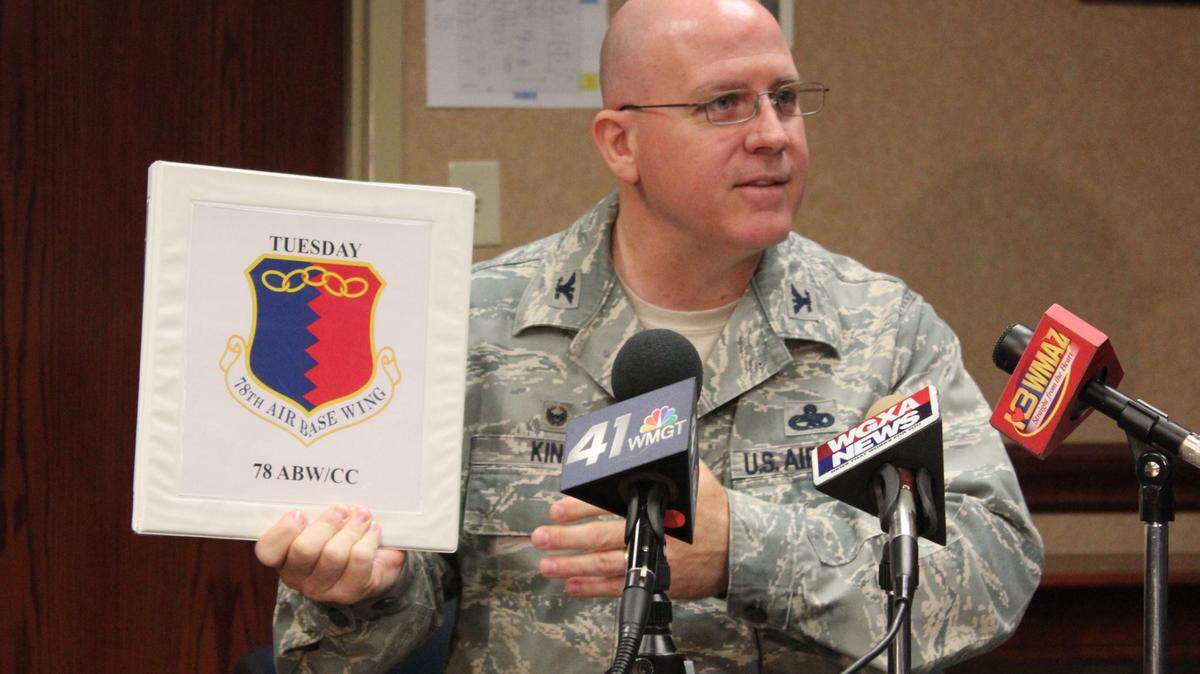 Col. Jeff King, 78th Air Base Wing commander, shows the wing's new emblem. "78th Air Base Wing" replaced "Above the Foe," on the emblem, which dated back to World War II when the wing operated pursuit aircraft.