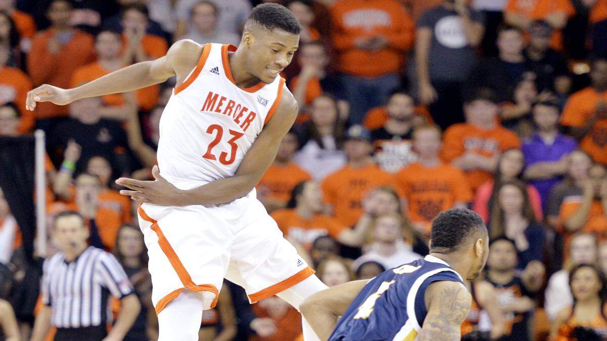 Mercer guard Demetre Rivers (23) leaps in the air while guarding Chattanooga's Johnathan Burroughs-Cook (4) during their game Monday night.