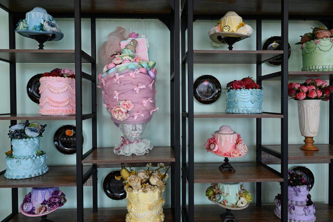 Prop cakes, many of them placed on top of hat brims, on a shelf inside of the new Mad Hatter Cafe & Confections in Warner Robins.