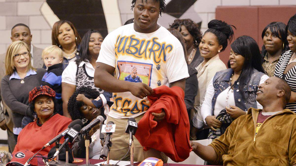 Dooly County defensive tackle Montravius Adams removes his jacket after he announced he was signing with Auburn on National Signing Day in 2013.