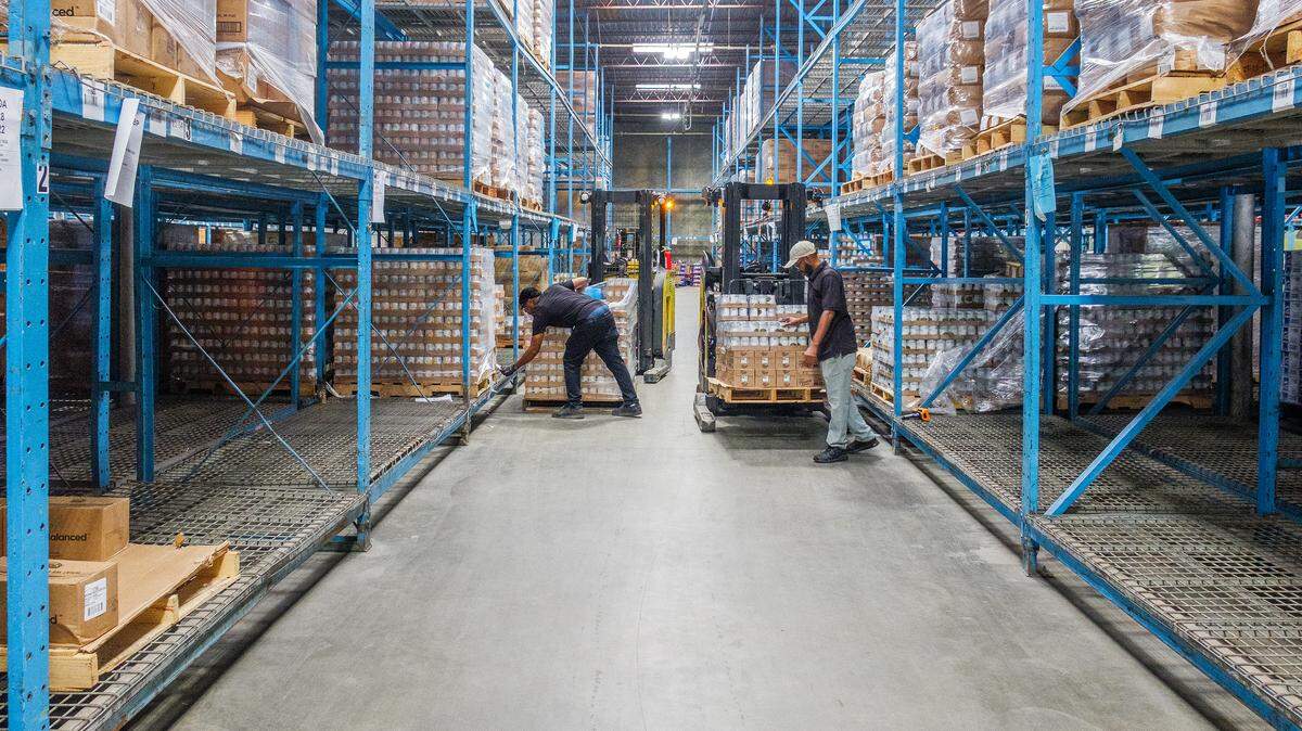 Workers among the partially empty racks at the Middle Georgia Community Food Bank warehouse in Macon on day 7 of the federal government shutdown. Cuts to USDA funding in March have left food banks weaker heading into the likely pause in SNAP funding.