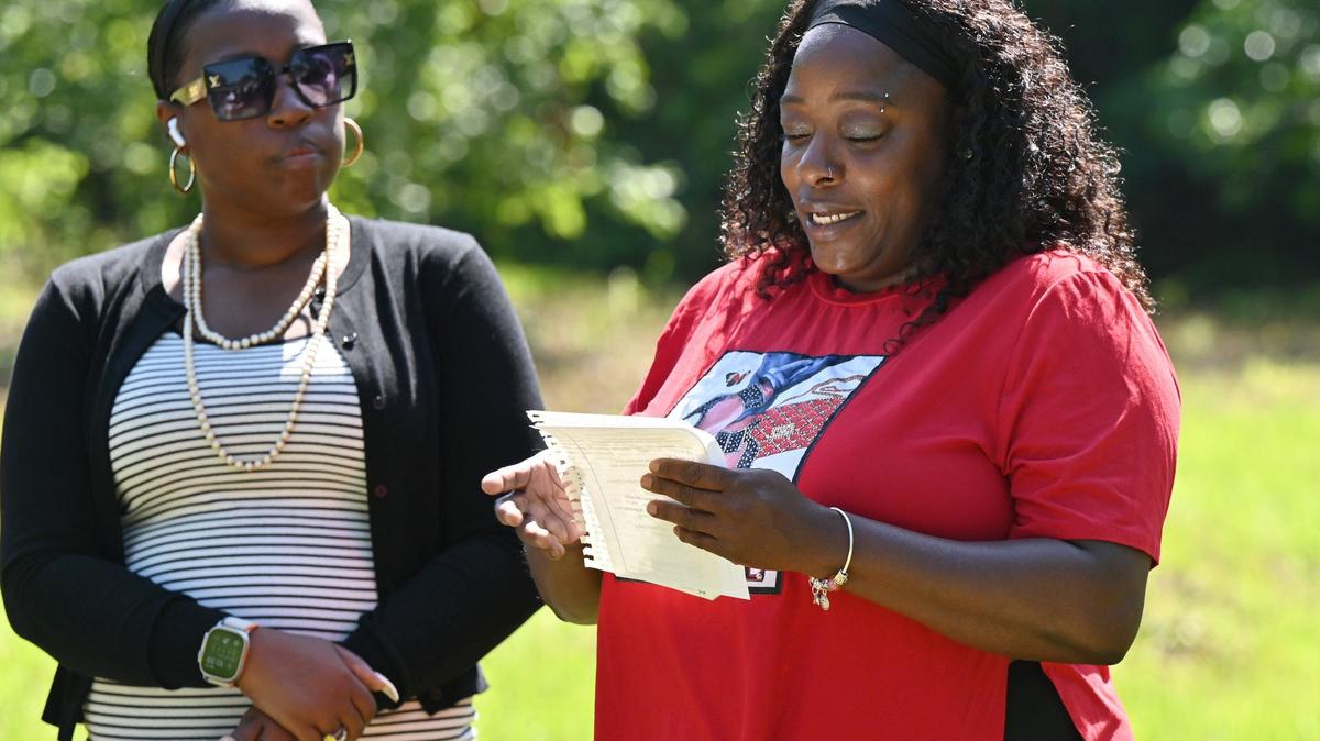 Future homeowner LaQuanda Ferguson (right) reads remarks next to Macon Area Habitat for Humanity board president Andrea Cooke during the Lynmore Estates ground blessing on Tuesday, May 28, 2024, in Macon, Georgia. Macon Area Habitat for Humanity held the ground blessing at a plot of land off of Dorothy Avenue where three future homes will be built.