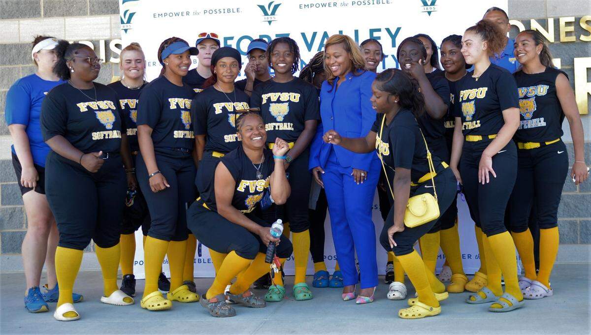 Students and coaches from the Fort Valley State softball team pose with athletic director Renae Myles Payne (center) at a press conference Thursday, March 23, 2023.