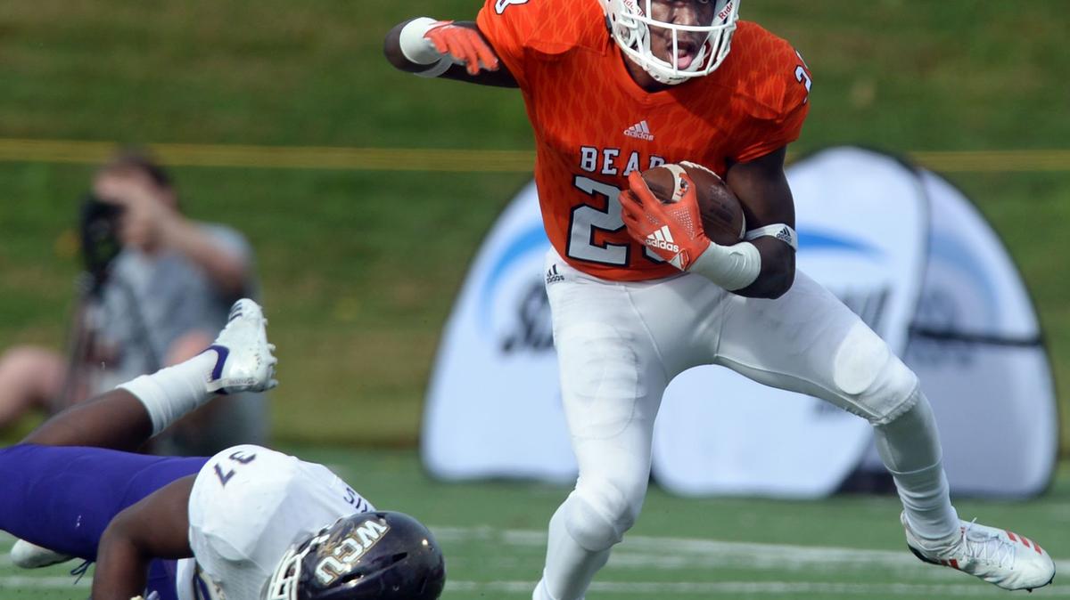 Mercer running back Tee Mitchell (28) steps away from Western Carolina linebacker Ty Harris (37) en route to a first half first down Saturday.  Mercer beat Western Carolina 59-46.