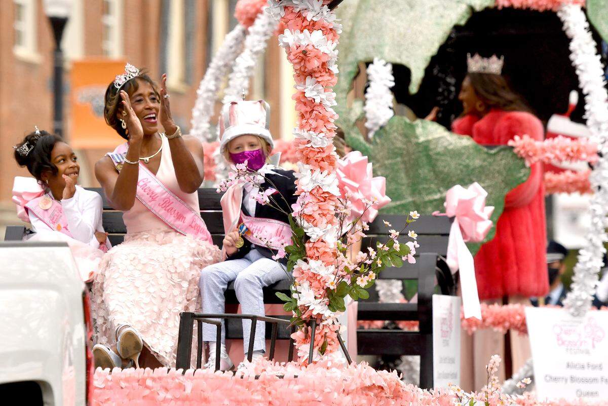 From left, Cherry Blossom Little Miss Khylie Wilkerson, Legacy Queen Angela Boykin and Little Mister Walden Weatherford wave at the crowd gathered along Cherry Street Sunday during the 39th Annual Cherry Blossom Parade.