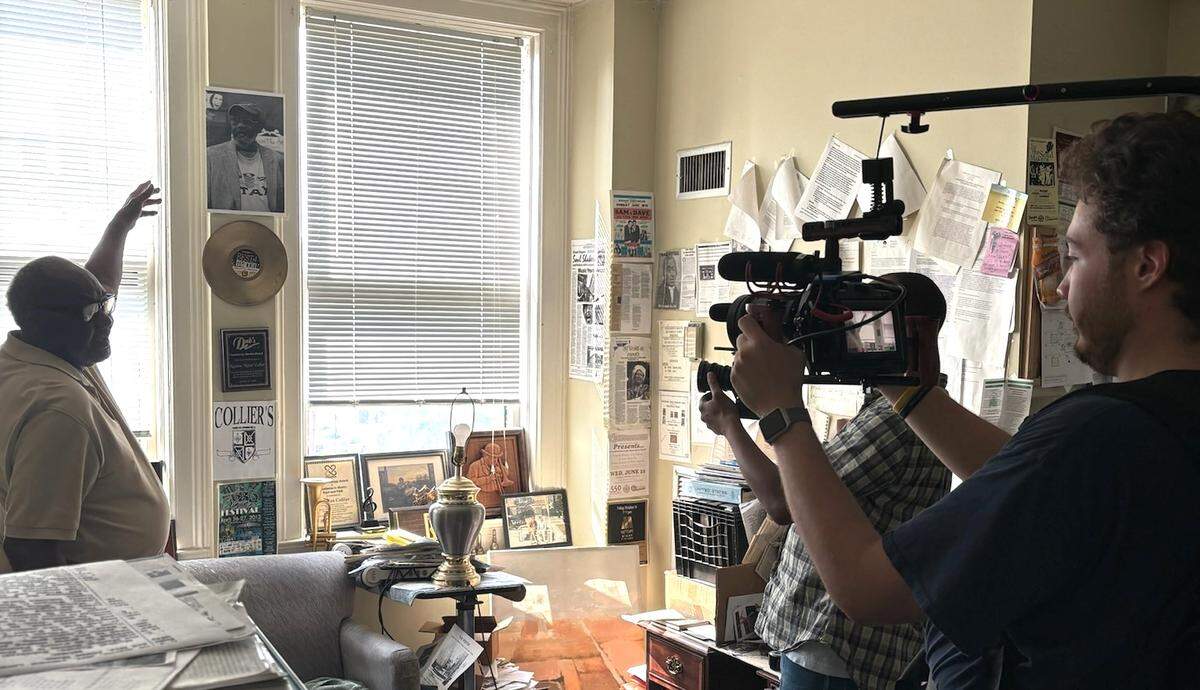 Macon native and musician Newton Collier points to photos, albums, and articles on his years in music. A new film "NEWT - A Short Documentary" celebrating his music career was recently filmed at several locations around Macon.