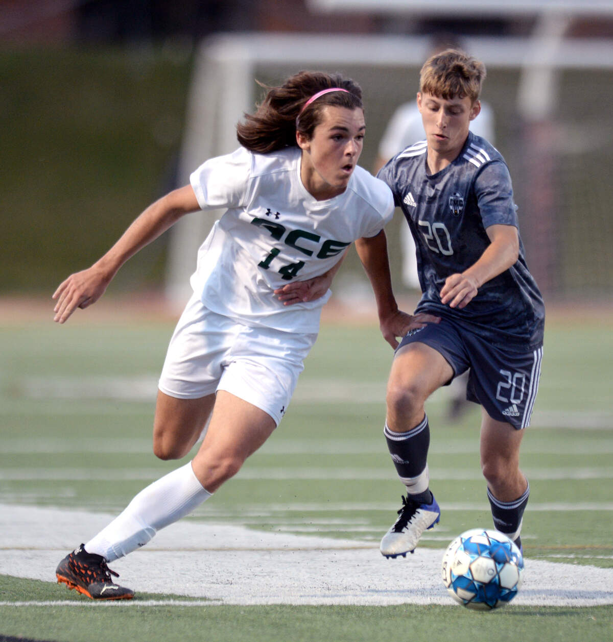 ACE midfielder James Waite (14) and GMC forward Owen Simpson (20) battle for the ball during their GHSA 1A State Championship match Friday night at Mercer.