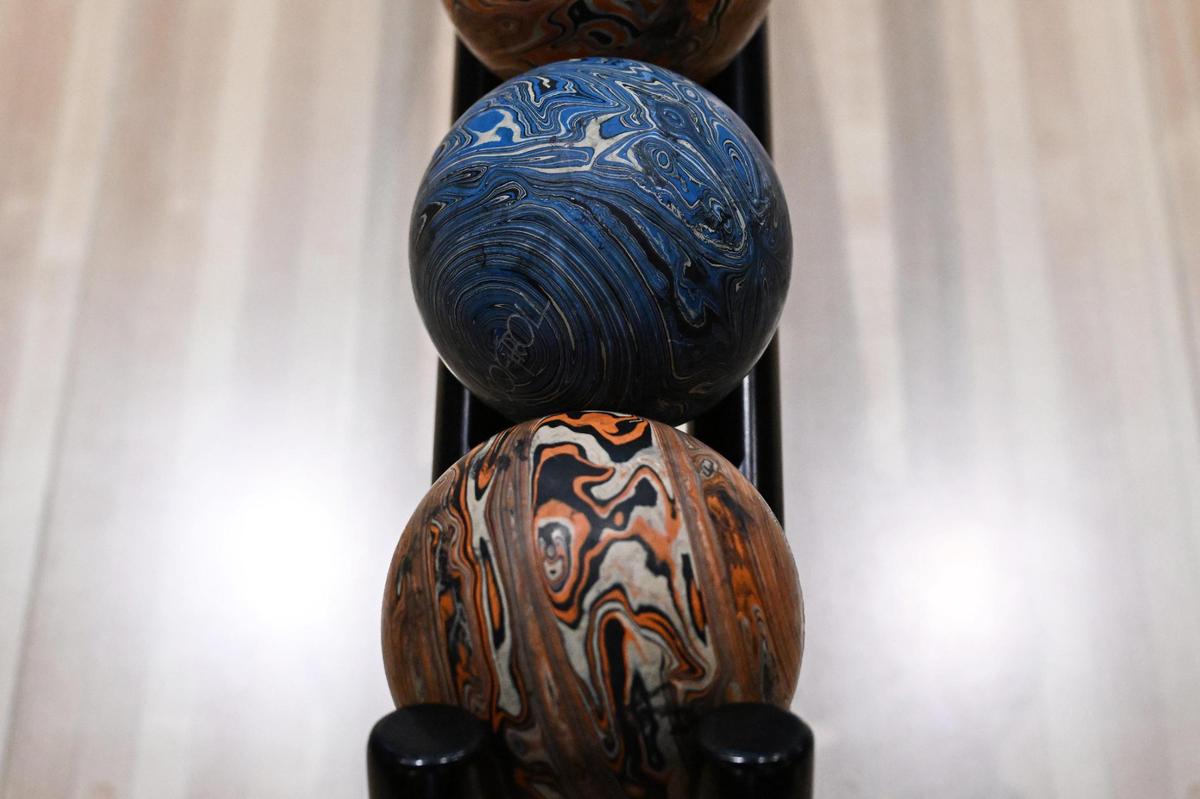 Duckpin bowling balls sit in a rack at the Social Duck on Friday, July 11, 2025, in downtown Macon, Georgia. Duckpin bowling uses smaller bowling balls and has shorter lanes and pins.