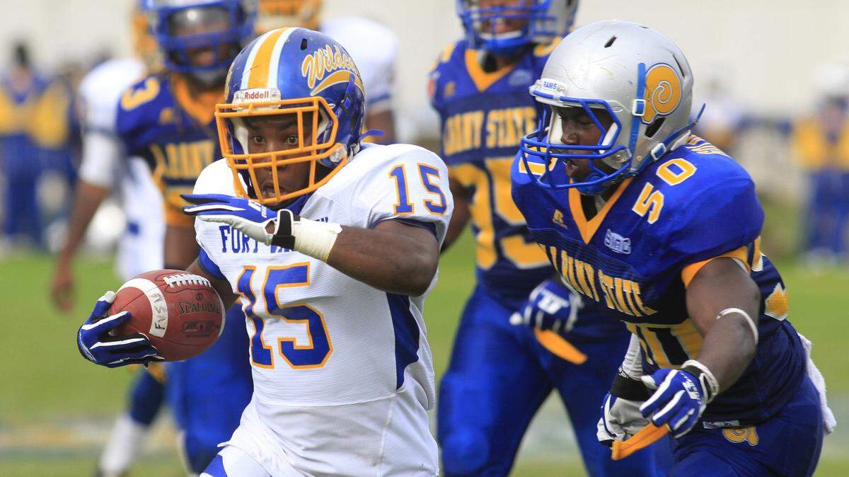 Fort Valley State running back Jalen White tries to get past Albany State's Emmauel Brown (50) and several other Golden Rams players during the first half Saturday in the Fountain City Classic in Columbus.