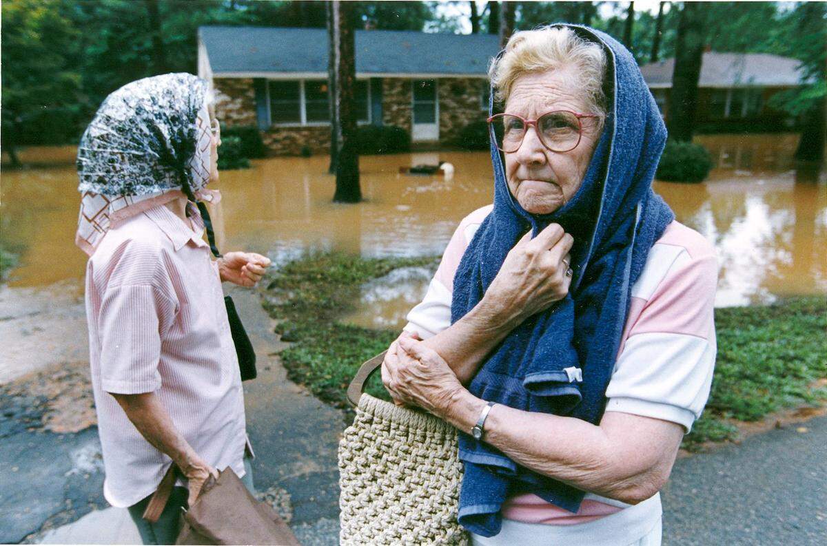 Two sisters who wished to remain unidentified inspect damage to houses on Delano Drive in Macon on July, 7, 1994, after floodwaters began to recede.