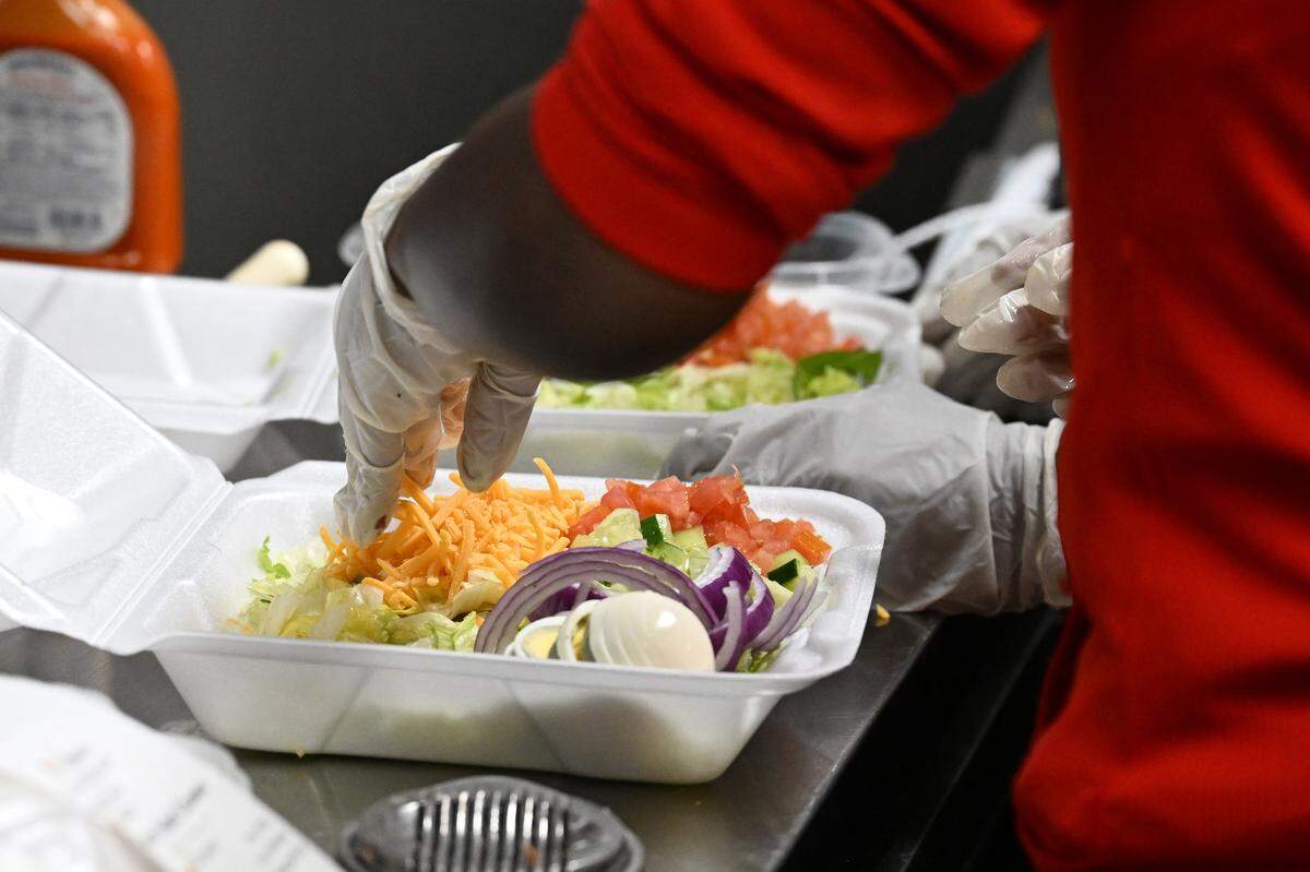 Staff at The Salad Palace build a to-go salad at the restaurant. Owner Tasha Williams said she gets to the restaurant at 7 a.m. to prep ingredients and chop vegetables.